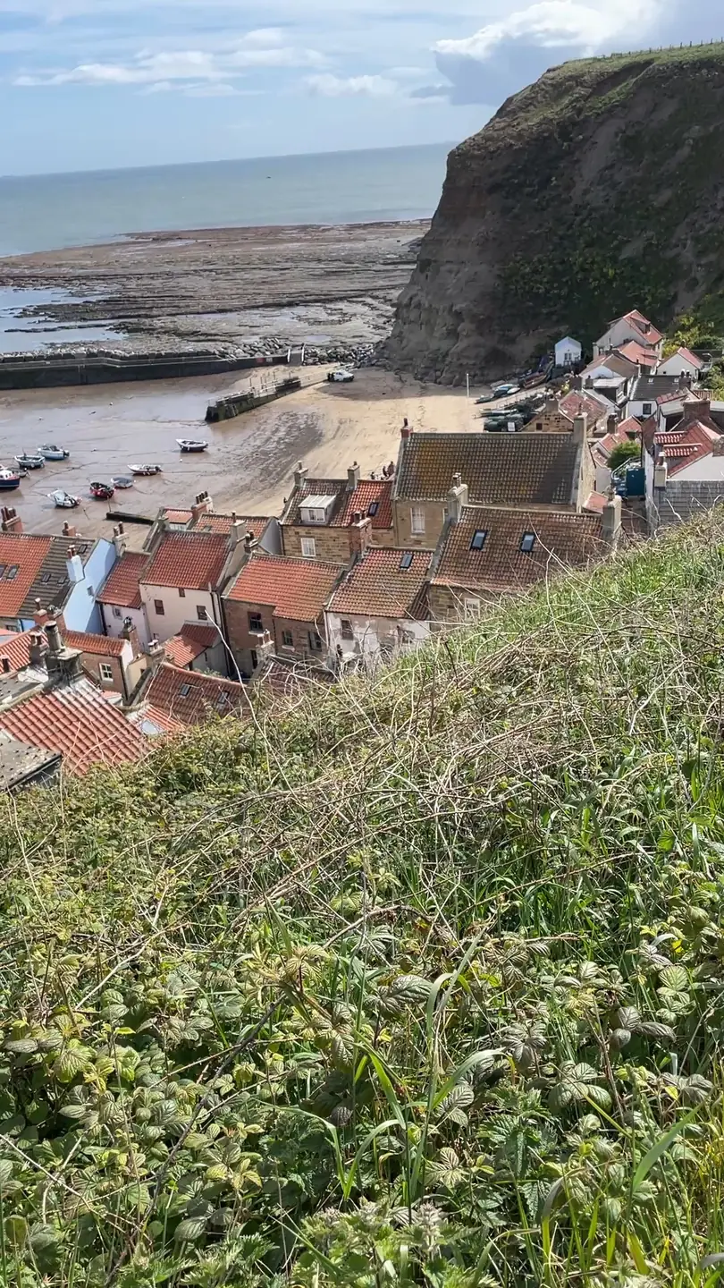 Staithes harbour and red-roofed cottages seen from the Cleveland Way clifftop